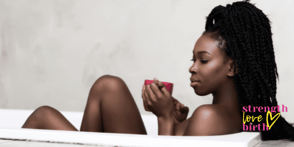 Beautiful woman sits in bath with cup of tea showing how beverages can be self care, especially while pregnant